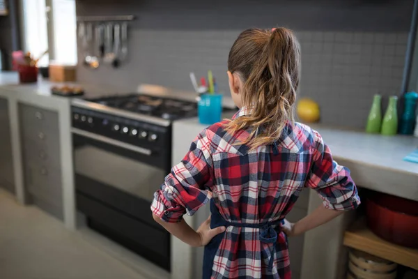 Chica posando usando un delantal en la cocina — Foto de Stock