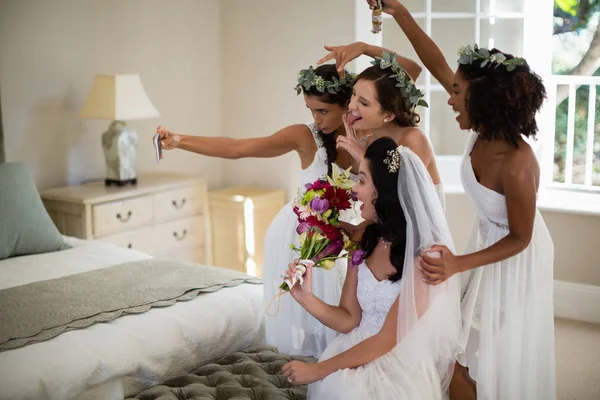 Bride and bridesmaid taking selfie at home — Stock Photo, Image