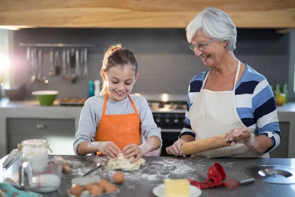 Granddaughter kneading dough — Stock Photo, Image