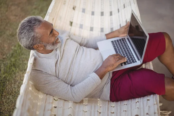 Homme utilisant l'ordinateur portable tout en se relaxant sur l'hamac — Photo