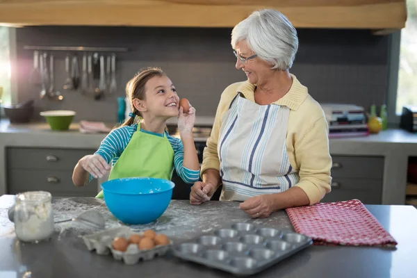 Granddaughter showing eggs to grandmother and smiling — Stock Photo, Image
