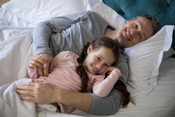 Padre e hija acostados en la cama en el dormitorio —  Fotos de Stock