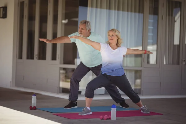 Casal sênior realizando exercício de alongamento — Fotografia de Stock