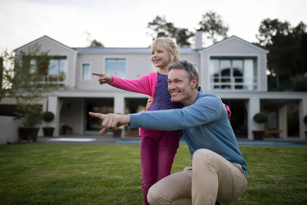 Far och dotter pekar i trädgården — Stockfoto