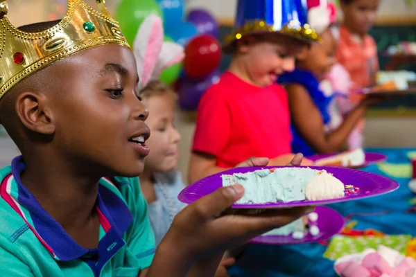 Хлопчик дивиться на торт в тарілці — стокове фото