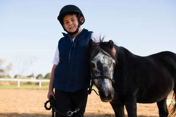 Menino segurando as rédeas de cavalo — Fotografia de Stock