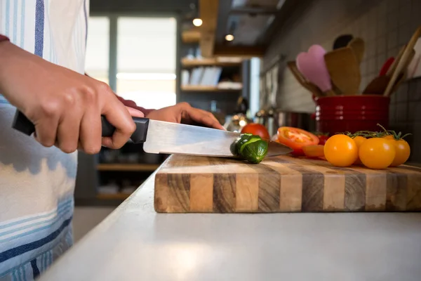 Mujer cortando calabacín en la cocina — Foto de Stock