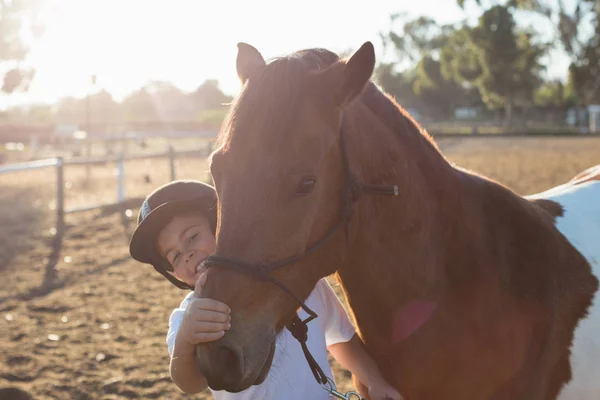 Rider boy acariciando um cavalo no rancho — Fotografia de Stock