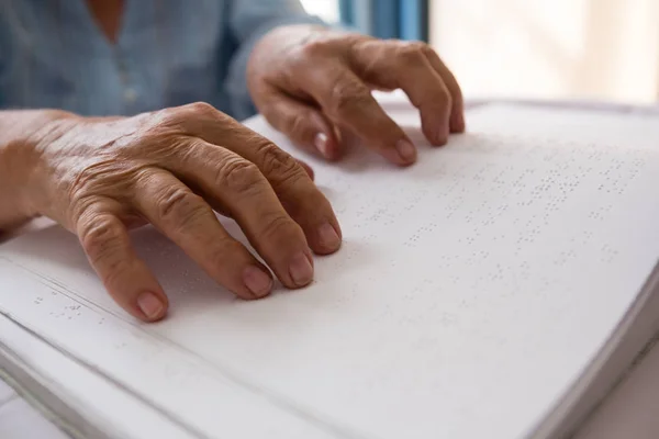 Rukou starší žena čte Braillovo písmo — Stock fotografie