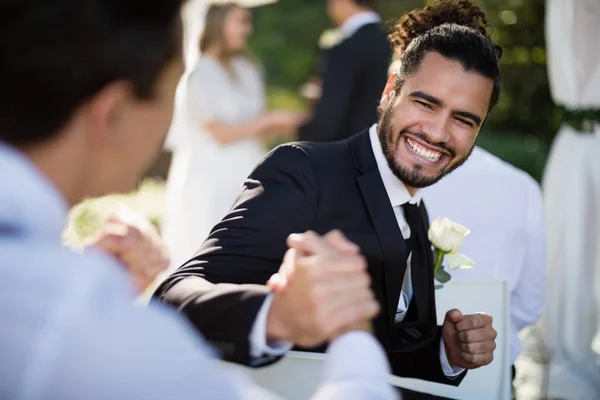 Man shaking hand with waiter during wedding — Stock Photo, Image