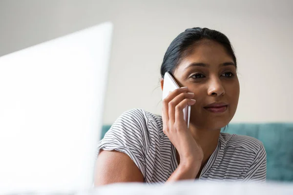 Vrouw met laptop praten over telefoon — Stockfoto