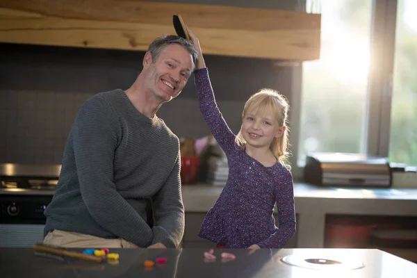 Daughter brushing fathers hair — Stock Photo, Image