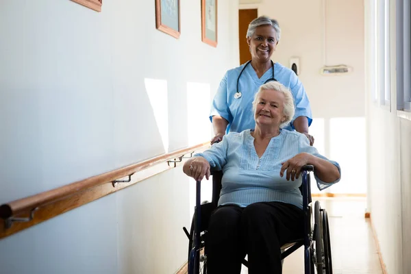 Verpleegkundige duwen patiënt in rolstoel — Stockfoto
