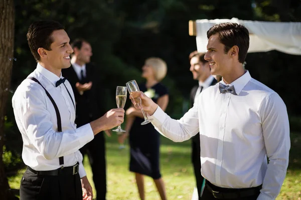 Waiters toasting champagne in park — Stock Photo, Image