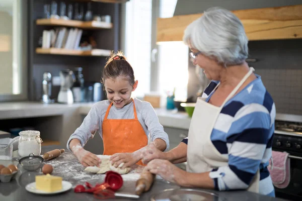 Granddaughter kneading dough — Stock Photo, Image