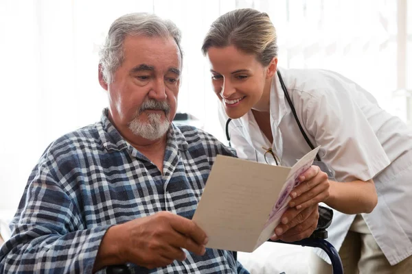 Läkare visar gratulationskort till patient — Stockfoto