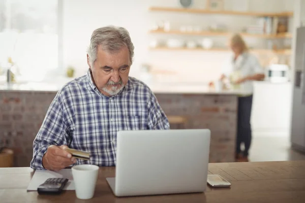 Uomo anziano che paga le bollette online sul computer portatile — Foto Stock