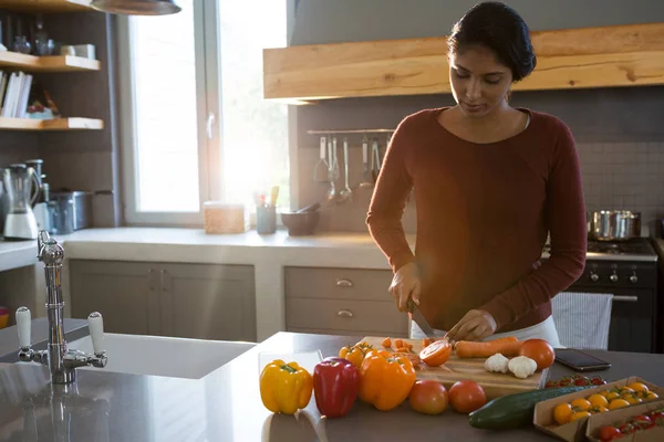 Donna che taglia verdure in cucina — Foto Stock