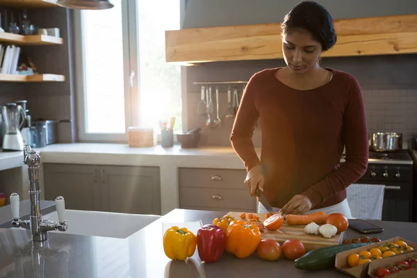 Woman cutting vegetables in kitchen — Stock Photo, Image