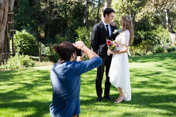 Photographer taking photo of newly married couple — Stock Photo, Image