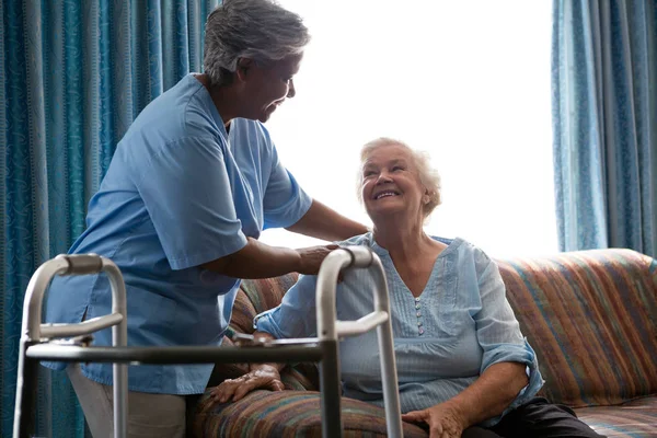 Медсестра помогает пожилой женщине стоять — стоковое фото