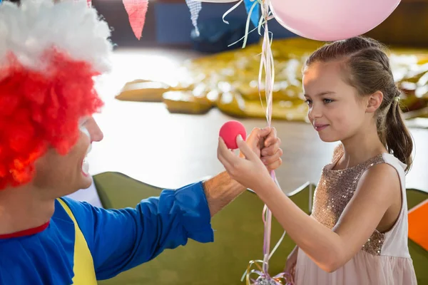 Palhaço e menina interagindo durante a festa de aniversário — Fotografia de Stock