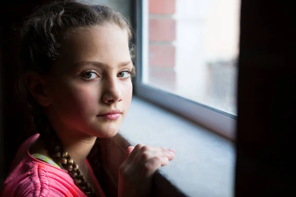 Adolescente chica de pie cerca de ventana — Foto de Stock