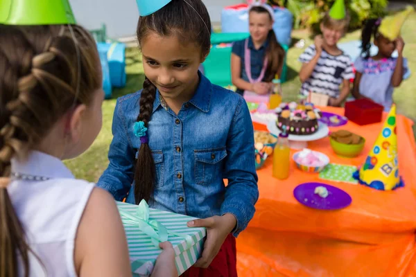 Chica dando regalo a un amigo — Foto de Stock