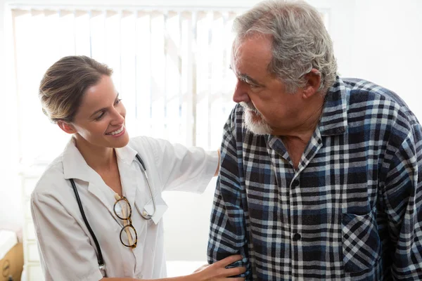 Ärztin hilft Seniorin beim Gehen — Stockfoto