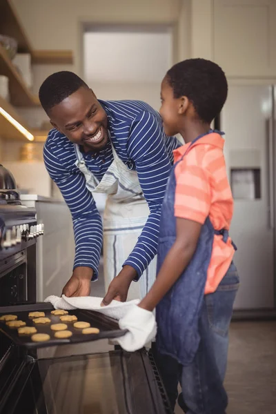Pai tomando bandeja de biscoitos frescos fora do forno — Fotografia de Stock