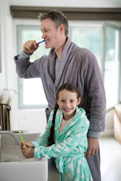 Pai e filha escovando os dentes no banheiro — Fotografia de Stock