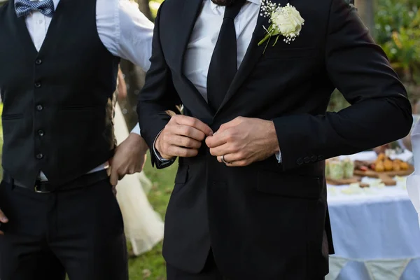 Bridegroom buttoning a wedding suit — Stock Photo, Image