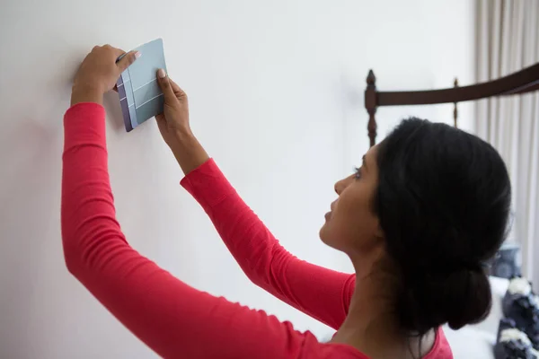 Mujer sosteniendo la muestra de color por la pared —  Fotos de Stock