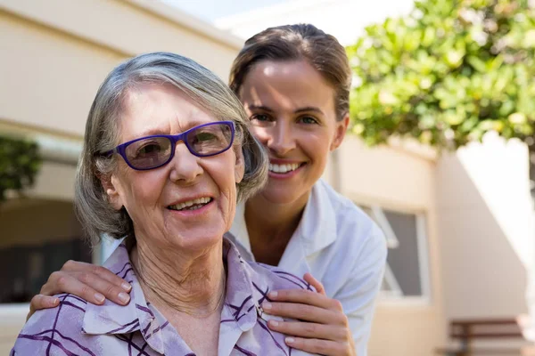 Sorridente donna anziana con medico — Foto Stock