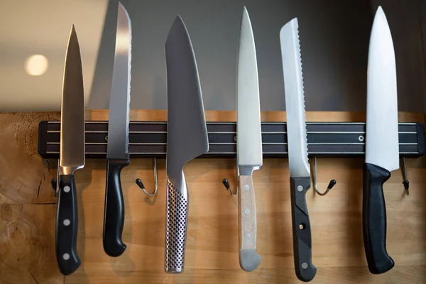 Set of kitchen knives hanging on wall — Stock Photo, Image