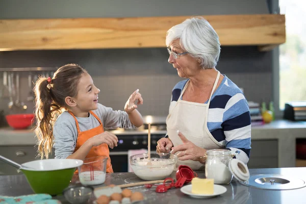 Kleindochter bloem op grootmoeders neus zetten — Stockfoto