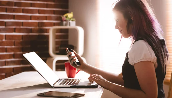 Executive using laptop and phone — Stock Photo, Image