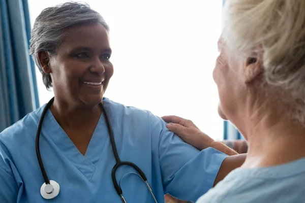 Медсестра разговаривает со старшим пациентом в доме престарелых — стоковое фото