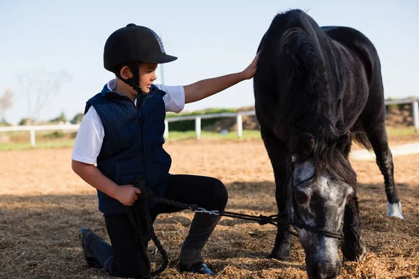 Rapaz segurando as rédeas de um cavalo — Fotografia de Stock