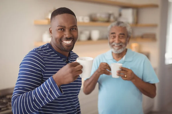 Père et fils ayant une tasse de café — Photo