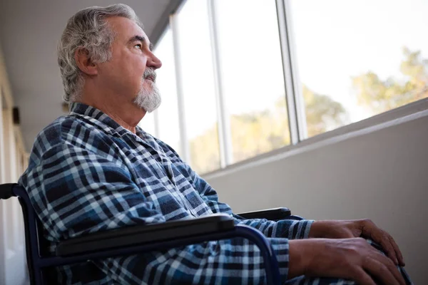 Tankeväckande senior man sittande på rullstol — Stockfoto