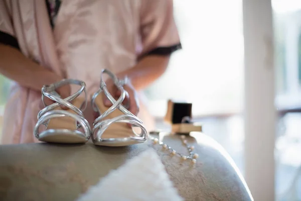 Bruid bedrijf paar sandalen — Stockfoto