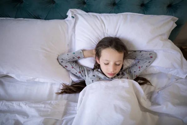 Chica durmiendo en la cama en el dormitorio — Foto de Stock