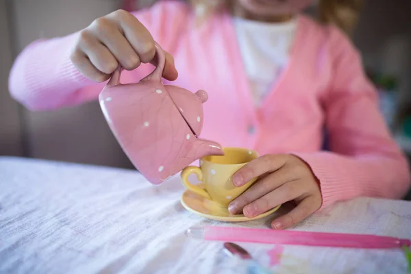 Girl pouring tea in the cup — Stock Photo, Image