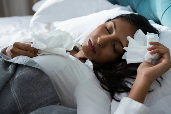 Mujer enferma con pañuelos durmiendo en la cama — Foto de Stock
