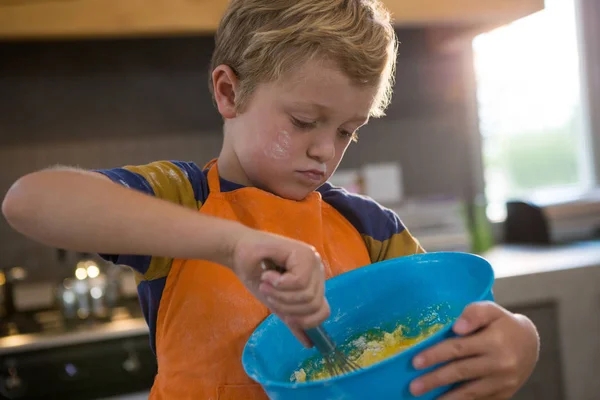 Boy mixing batter in blue container — Stock Photo, Image