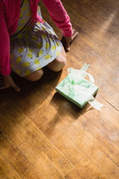 Menina sentada com caixa de presente no chão — Fotografia de Stock