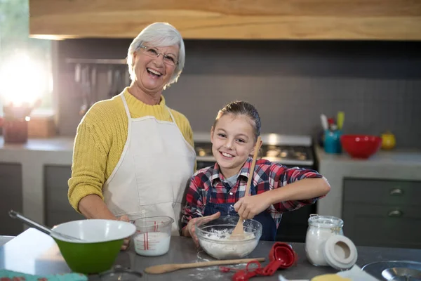 Granddaughter mixing flour in a bowl — Stock Photo, Image