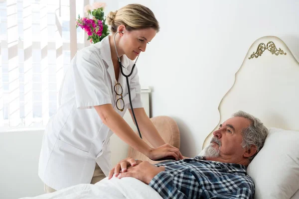 Läkare Lyssna på hjärtslag av äldre man — Stockfoto