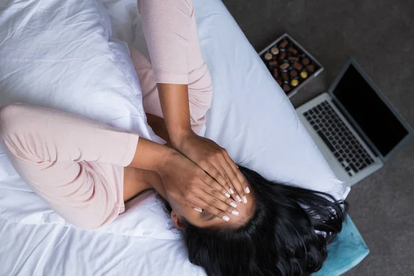 Mulher cobrindo rosto na cama — Fotografia de Stock